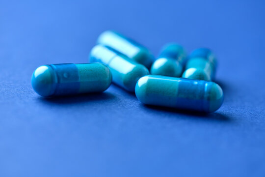 Amino acids capsules on paper background. Soft focus. Close up.