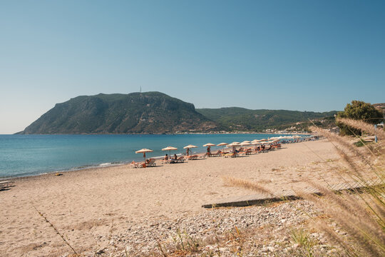 View from Kefalos Beach on the Greek island of Kos, with lounge chairs and a mountain in the background.