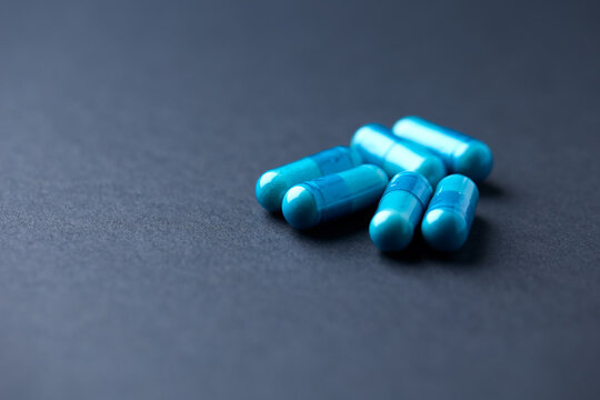 Multivitamin tablets on bright paper background. Close up. Copy space.