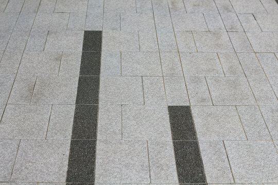 Modern granite paving with contrasting dark stone accents in a geometric pattern