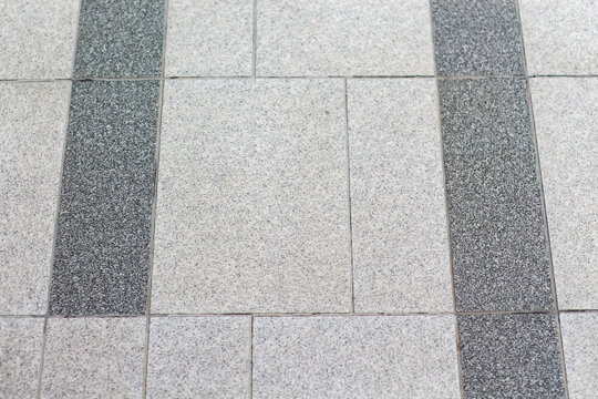 Textured granite paving stones with a contrasting dark stripe pattern