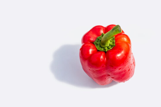 Red bell pepper close-up on a white background with shadow. Fresh red vegetables. 