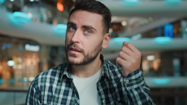 Pensive thoughtful Caucasian man thinking pondering coming up with idea looking at camera raising finger hesitate business male businessman European guy client ponder finding solution in shopping mall