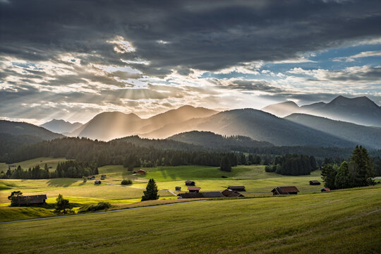 Sonnenlicht, das durch die Wolken &uuml;ber einem Alpental bricht und eine besondere Atmosph&auml;re schafft