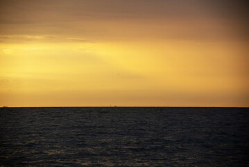 Fototapeta premium Sunset Over Ocean Horizon with Calm Waters