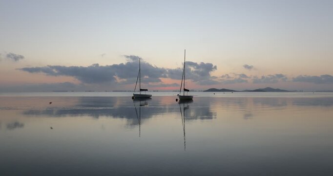 View of the Mar Menor at dawn with two boats on its waters, Punta Prima, Cartagena, Region of Murcia, Spain