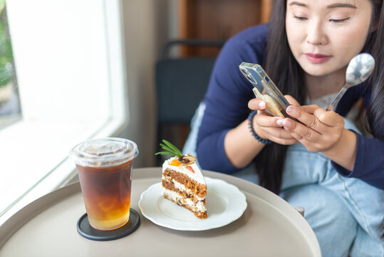 Woman Using Smartphone Near Dessert in Cafe