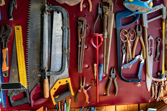 Vintage hand tools arranged on workshop wall background
