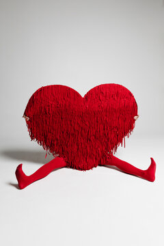 Person Holds Red Heart Shape With Fringes 