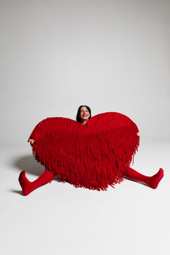 Woman holding large red heart celebrating love and joy