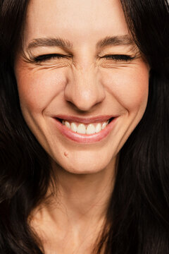 Woman Smiles Broadly With Closed Eyes and a Joyful Expression