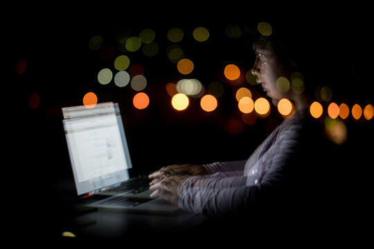  Working on Laptop at Night with City Lights