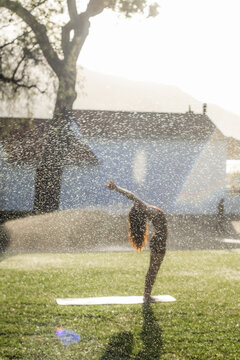 Morning Yoga Stretch with Garden Sprinklers in the morning