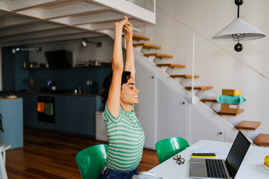 Woman stretching at home studio during remote work break ugc