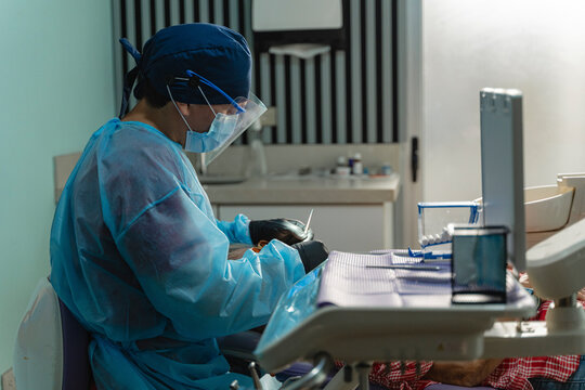 Dental professional operating on patient with protective gear