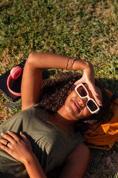 Young student relaxing with backpack in the sun