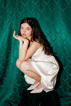 Young woman crouching with classic elegant style