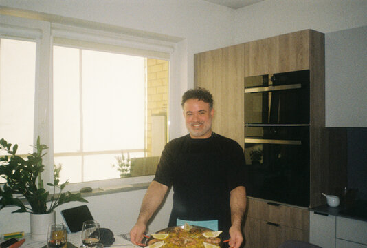 Happy Man Holding Paella in The Kitchen 