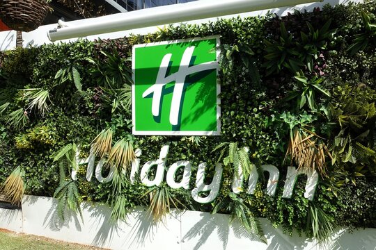 The Holiday Inn emblem is displayed on a contemporary living wall or vertical garden, showcasing vibrant green foliage and tropical vegetation