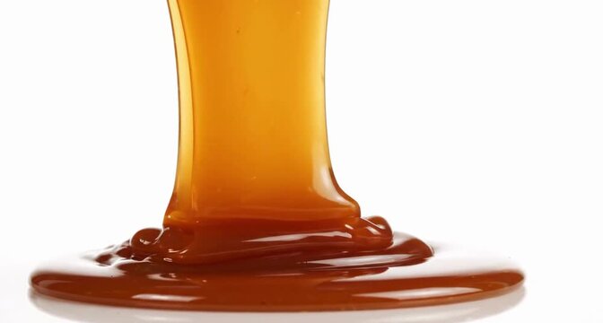 Warm caramel stretches into glossy flowing ribbons, creating rich reflections and luxurious dessert appeal