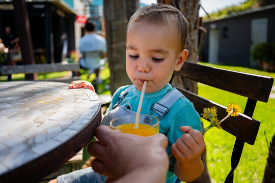Toddler drinking orange juice