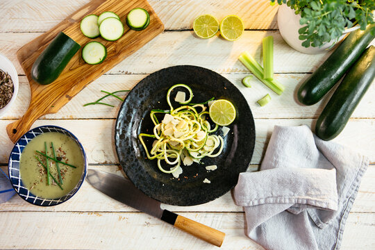Zucchini spaghetti on black plate with lime