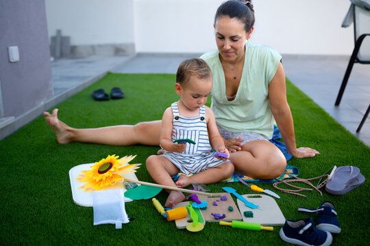 Mother and toddler playing with playdough outdoors