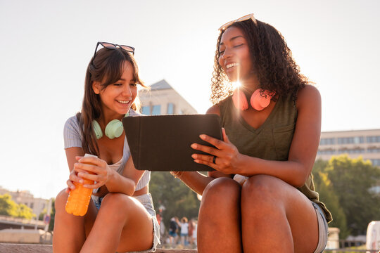 Teen girls enjoying outdoor learning on digital tablet