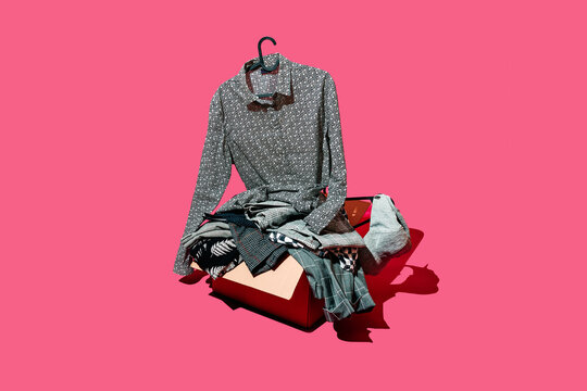 a patterned shirt hangs above a box filled with clothes