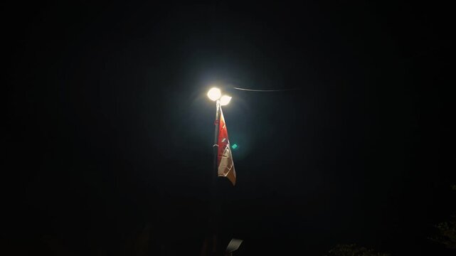 Indonesian Flag Waving at Night Under Street Light