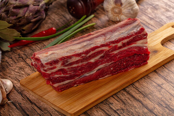 Raw beef rib on wooden cutting board with garlic chili and artichoke © Andrei Starostin