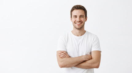 Fototapeta premium Professional visualization of smiling man standing with crossed arms on a white background, perfect for promotional and modern