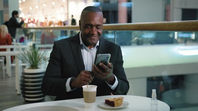 Mature African American business man with mobile phone take picture selfie photo in cafe with coffee tea and tasty cake middle-aged businessman male manager posing for photography with smartphone app