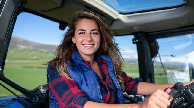Young woman farmer driving tractor on rural farm