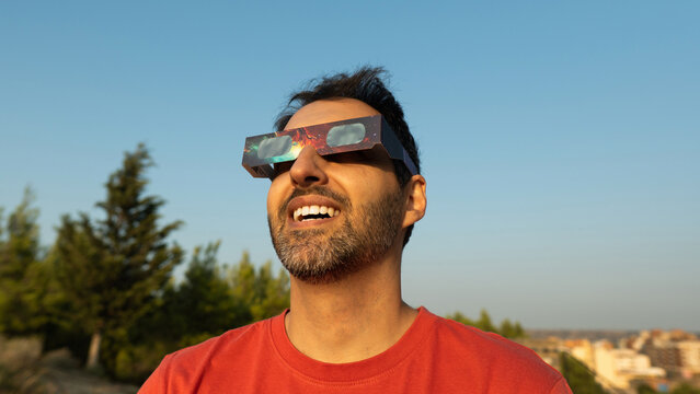 Man observing a solar eclipse safely with protective glasses