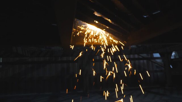 Many bright sparks fly from hot metal during plasma cutting with a cnc. Manufacturing a workpiece from steel. Laser cutter in work. Industrial metalworking production. Making details at workshop