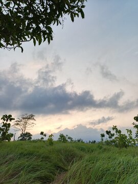 Grassland Hill at Sunset with Moody Dramatic Clouds and Scenic Sky View