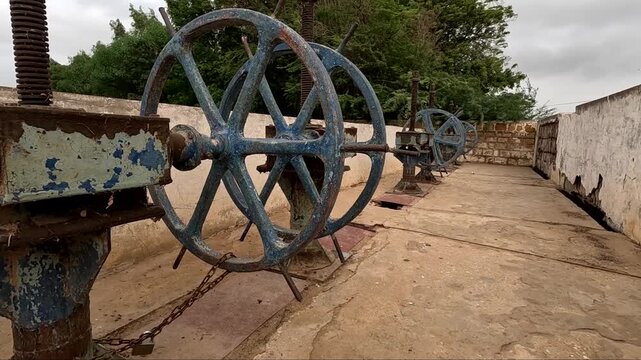 Rusty Old Blue Dam Sluice Gate Wheels on Concrete Dam Top