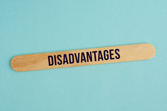 Disadvantage word concept on cubes wood with plain background.