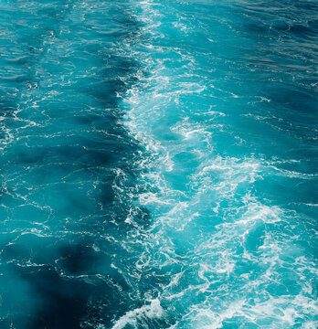 Vibrant turquoise sea with foamy waves forming an organic natural pattern, perfect as a water background.