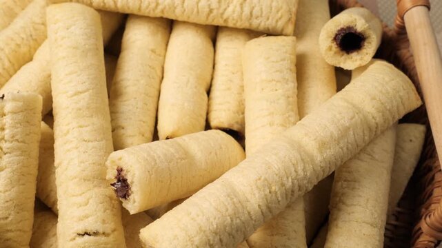 Wafer rolls with chocolate slowly moving in a wicker basket
