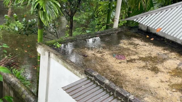 Raindrops Creating Ripples on Concrete Rooftop During Rainstorm
