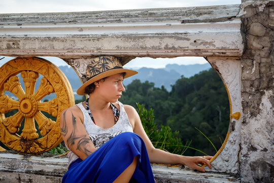 Female traveler looking at the mountain view from a temple terrace in Krabi, Thailand