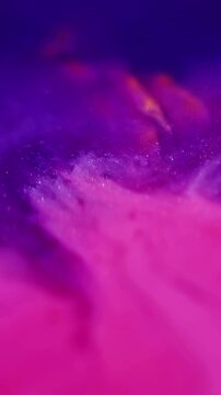 Vertical video. Ink water. Bokeh particles. Defocused pink blue colorful marble texture chemical shimmering fluid spreading on abstract background.