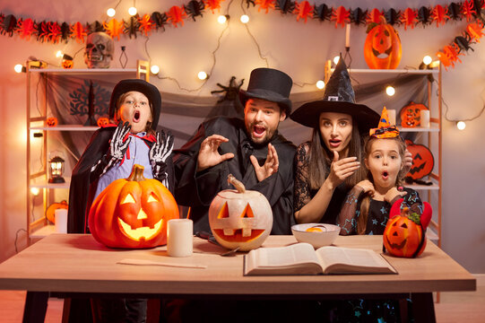 Parents and children have fun together, celebrating halloween at home in costumes. Party includes pumpkins, decorations, and themed activities, creating a joyful and entertaining holiday experience.