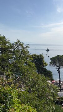Panoramic view of resort beach resort with umbrellas, pine trees and turquoise sea bay in Taormina Sicily Italy