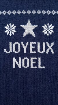 joyeux noel text with snowflakes and star on cozy blue woolen holiday sweater