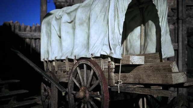 Covered wagon parked outside wooden fort, sunlit canvas, weathered wheel, palisade backdrop, prairieready supplies, authentic rustic textures and clear blue