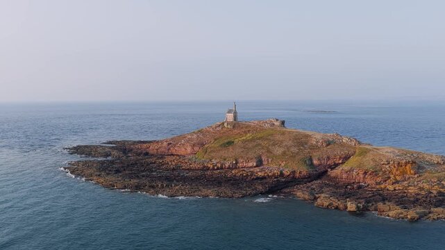 Aerial view of Ilot Saint Michel, a small rocky island off the coast of Erquy in Brittany, France, featuring the historic chapel at the summit.