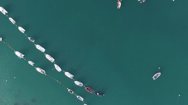 Aerial view of rows of boats and yachts moored in the calm turquoise waters of Port de Ploumanac'h, located in Perros-Guirec, Brittany, France.